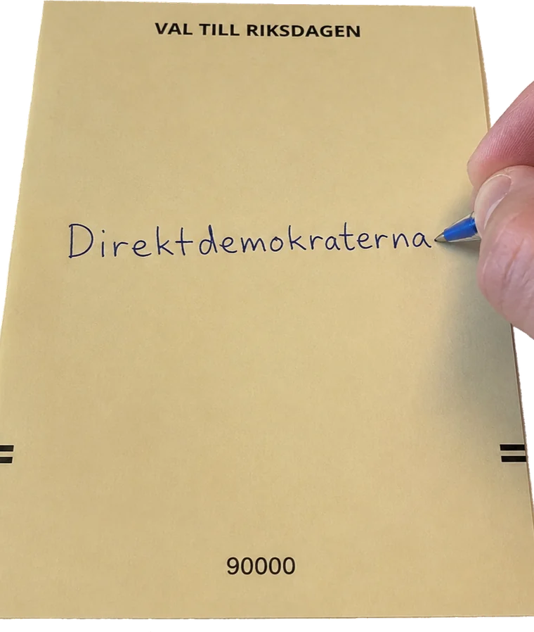 En hand skriver Direktdemokraterna med bläckpenna på en tom gul riksdagsvalsedel